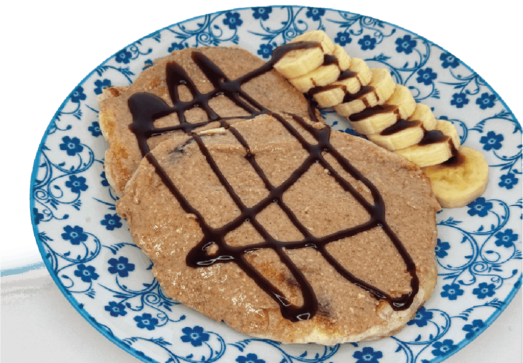 Two pancakes topped with a light brown spread, chocolate drizzle, and sliced bananas are served on a blue floral plate.