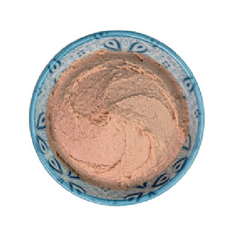 A smooth, swirled spread of liver sausage fills a small patterned bowl.