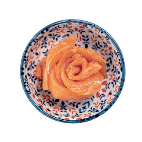 Thin slices of smoked salmon are artfully arranged in a rose shape within a small patterned bowl.