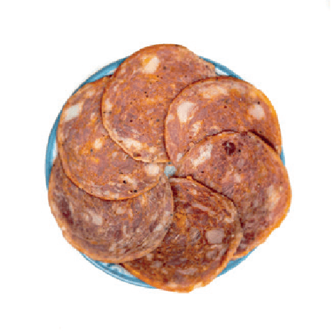 Several round slices of Spanish salami are fanned out on a small plate.